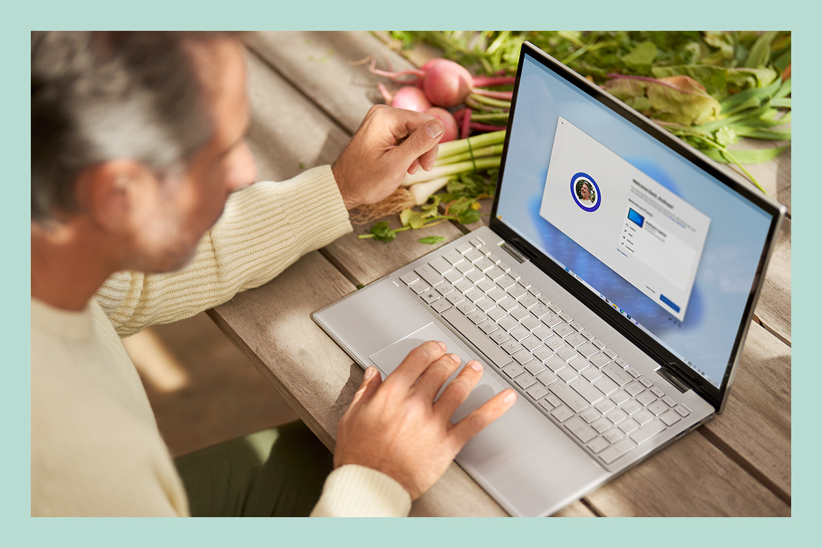 Um homem a usar um portátil para configurar ficheiros, aplicações e configurações padrão existentes através do Windows 11.